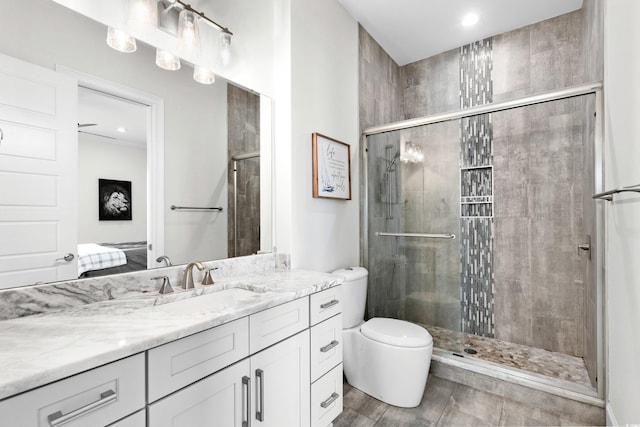 bathroom with walk in shower, vanity, and toilet