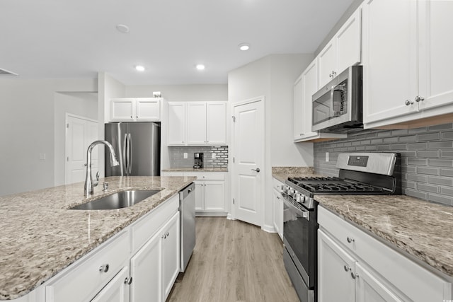 kitchen with white cabinetry, light hardwood / wood-style floors, stainless steel appliances, and sink