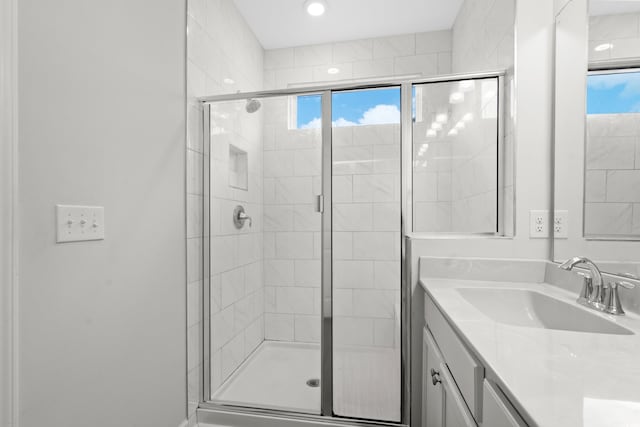 bathroom featuring walk in shower and vanity