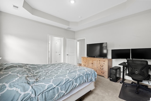 bedroom featuring a tray ceiling and light carpet