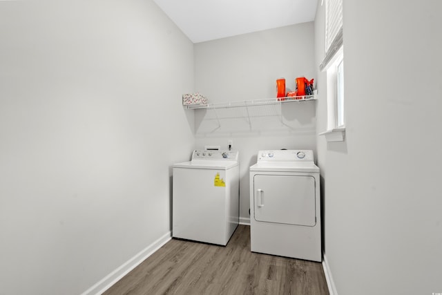 clothes washing area with light hardwood / wood-style floors and washing machine and clothes dryer