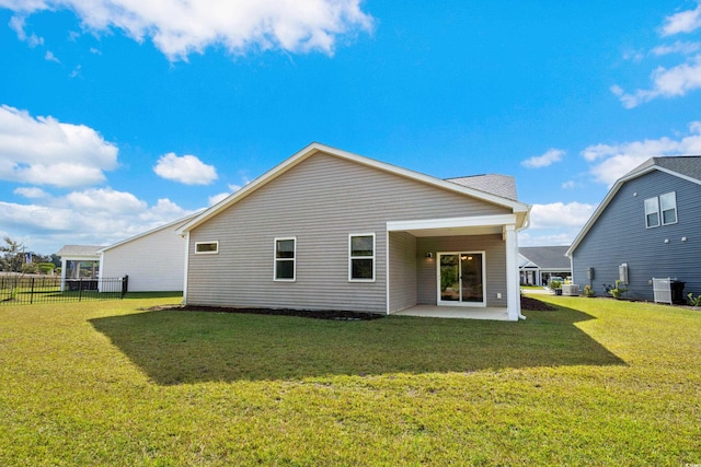 back of property with central AC unit, a lawn, and a patio area