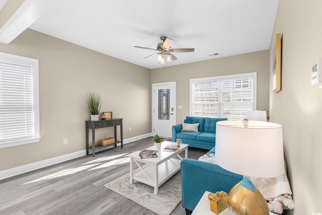 living room with beamed ceiling, hardwood / wood-style flooring, and ceiling fan