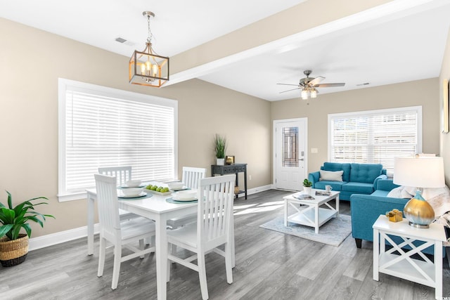 dining room featuring wood-type flooring and ceiling fan with notable chandelier