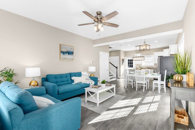 living room featuring dark hardwood / wood-style flooring and ceiling fan with notable chandelier