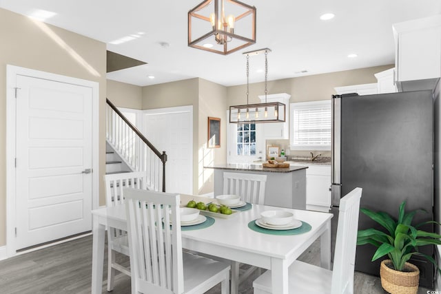 dining area featuring sink, an inviting chandelier, and dark hardwood / wood-style floors