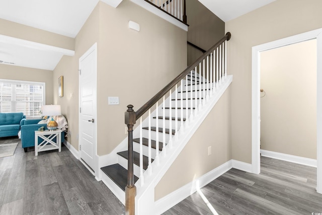 stairs featuring hardwood / wood-style flooring and vaulted ceiling with beams