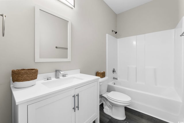 full bathroom featuring hardwood / wood-style floors, vanity, toilet, and  shower combination