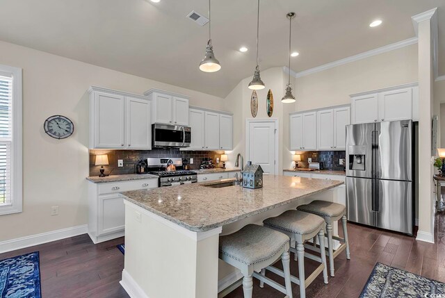 kitchen with a center island with sink, appliances with stainless steel finishes, a healthy amount of sunlight, and white cabinets