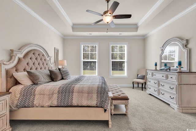 carpeted bedroom with ornamental molding, ceiling fan, and a raised ceiling