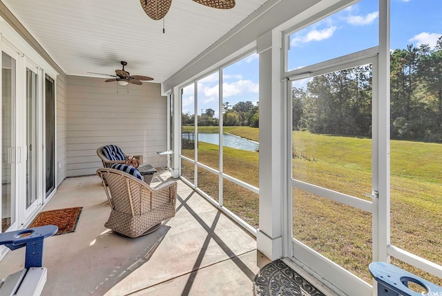 sunroom / solarium featuring a water view