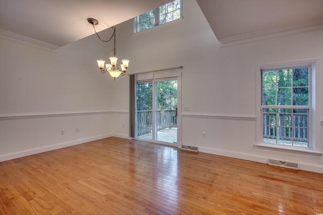 spare room featuring crown molding, a chandelier, and light hardwood / wood-style flooring