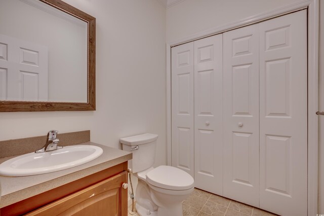 bathroom with tile patterned flooring, vanity, and toilet