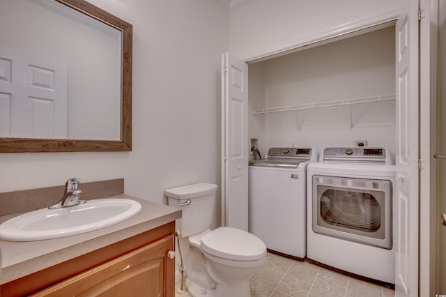 bathroom with toilet, tile patterned flooring, vanity, and washing machine and clothes dryer