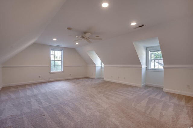 additional living space featuring ceiling fan, light colored carpet, and lofted ceiling