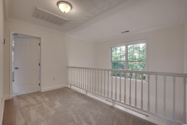 empty room with ornamental molding and light colored carpet