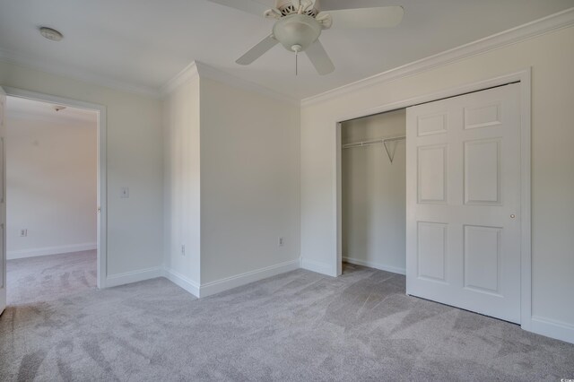 unfurnished bedroom with ceiling fan, light carpet, a closet, and crown molding