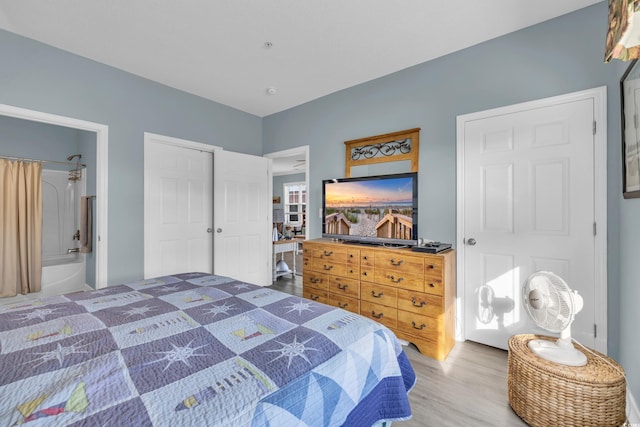 bedroom featuring connected bathroom and hardwood / wood-style floors