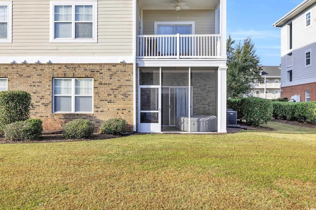 rear view of house featuring a balcony and a lawn