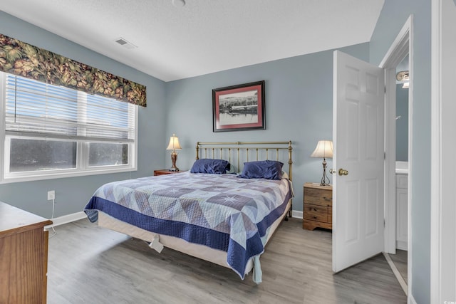 bedroom featuring a textured ceiling and light hardwood / wood-style floors