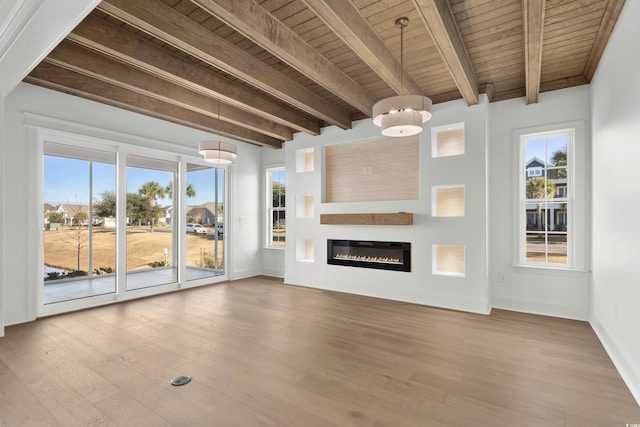 unfurnished living room with beamed ceiling, wooden ceiling, and light wood-type flooring