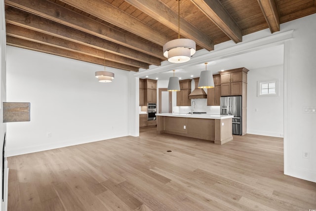 kitchen with beam ceiling, sink, stainless steel appliances, decorative light fixtures, and custom range hood