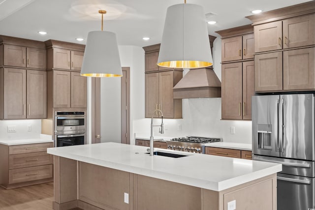 kitchen featuring sink, pendant lighting, stainless steel appliances, and light wood-type flooring