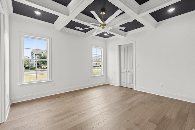 spare room with beamed ceiling, light hardwood / wood-style floors, crown molding, and coffered ceiling