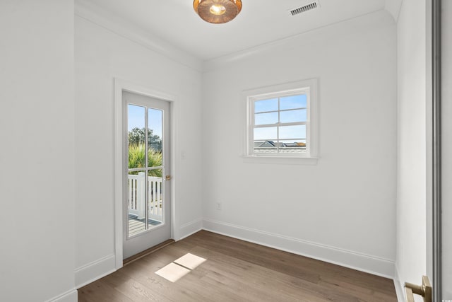 spare room with wood-type flooring and ornamental molding