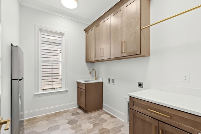 washroom with hookup for a washing machine, sink, ornamental molding, and hookup for an electric dryer