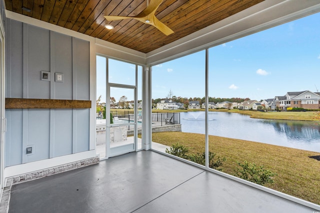 unfurnished sunroom with a water view and wooden ceiling