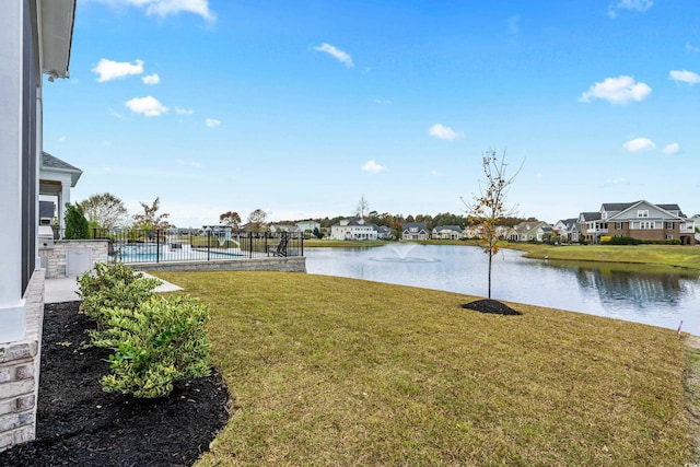 view of yard with a fenced in pool and a water view