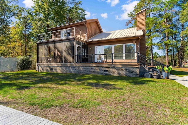 back of house with a lawn, a sunroom, and a balcony