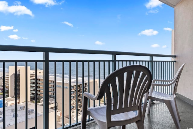 balcony with a water view and a view of the beach