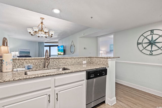 kitchen with light wood-type flooring, an inviting chandelier, sink, white cabinets, and stainless steel dishwasher