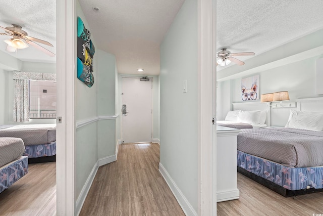 hall featuring a textured ceiling and light hardwood / wood-style floors