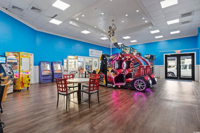 rec room featuring a drop ceiling, a towering ceiling, and dark hardwood / wood-style floors