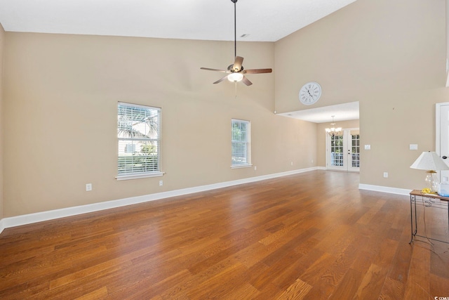 unfurnished living room with wood-type flooring, plenty of natural light, and high vaulted ceiling