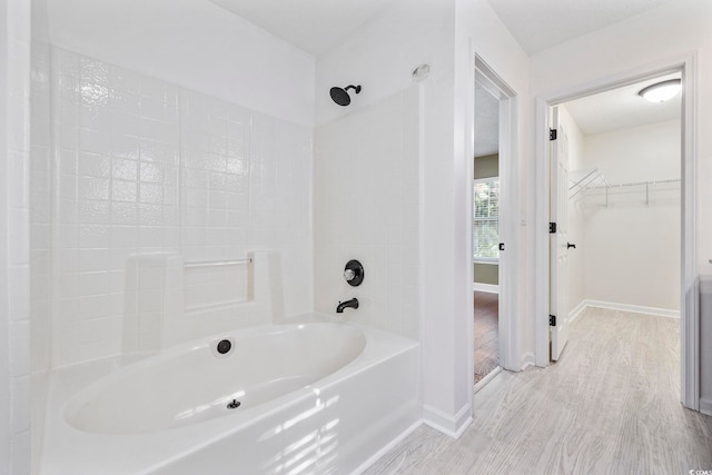 bathroom with shower / bathing tub combination and hardwood / wood-style floors