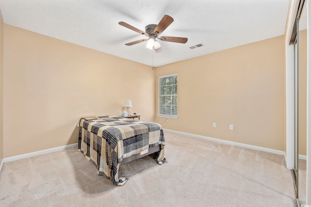 carpeted bedroom featuring a textured ceiling and ceiling fan