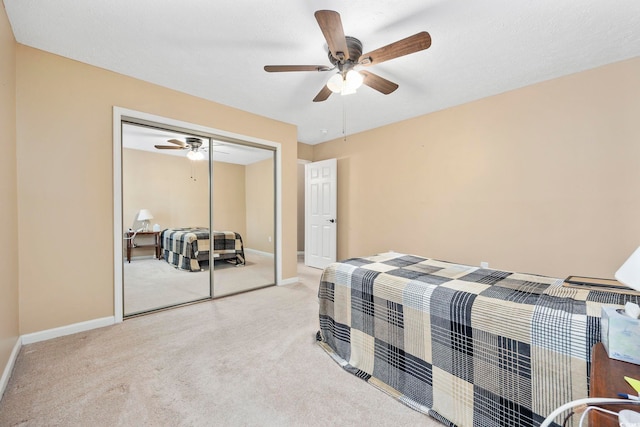 carpeted bedroom with ceiling fan and a closet