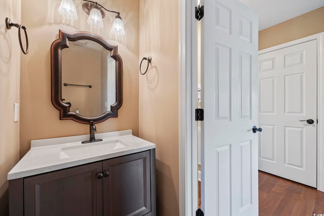 bathroom featuring wood-type flooring, vanity, and a textured ceiling