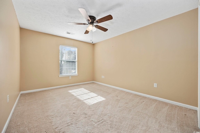 carpeted spare room featuring a textured ceiling and ceiling fan