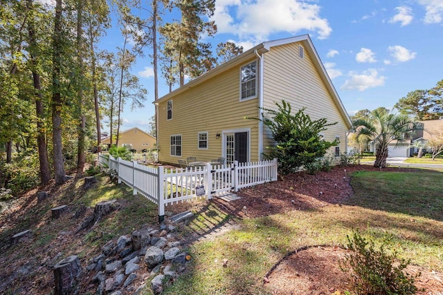 rear view of property featuring a lawn