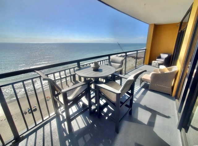 balcony with a water view and a beach view