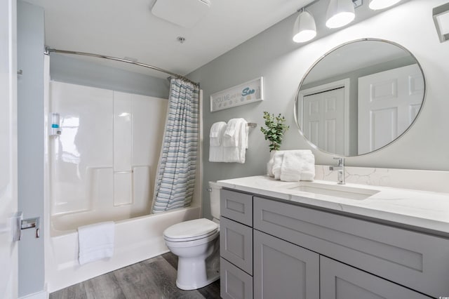 full bathroom featuring hardwood / wood-style floors, shower / bath combination with curtain, toilet, and vanity