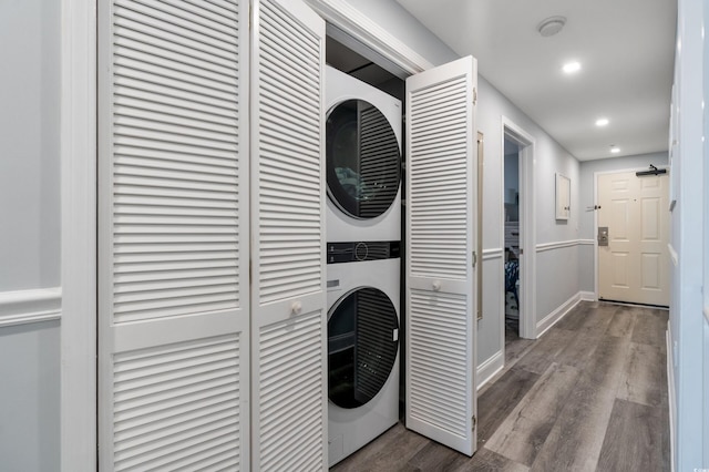 washroom featuring hardwood / wood-style floors and stacked washing maching and dryer