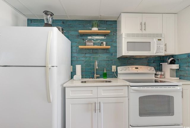 kitchen featuring backsplash, sink, white cabinets, and white appliances