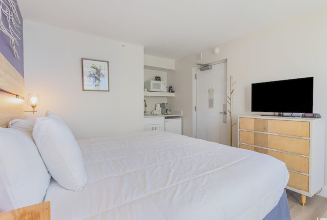 bedroom featuring light hardwood / wood-style floors and sink