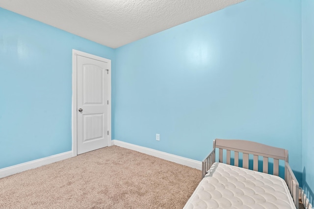 unfurnished bedroom with a textured ceiling and carpet flooring